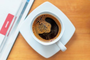 Tahta masanın üzerinde beyaz kahve fincanı..