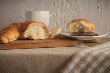 Kahveli kruvasan, çikolatalı, kahvaltıda çay. Sabah kırsal masa. Ekmek için erik reçeli. Kırsal eğlence..