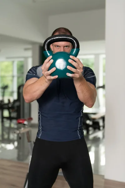 Fitnessmann mit Kettlebells im Fitnessstudio — Stockfoto