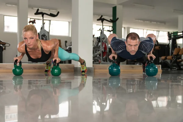 Fitnesspaar mit Kettlebells im Fitnessstudio — Stockfoto
