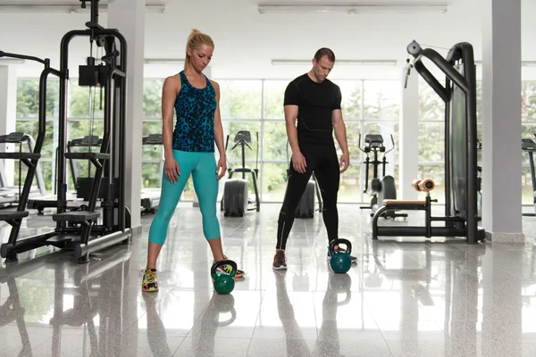 Fitness Couple Using Kettlebells Inside Gym — Stock Photo, Image