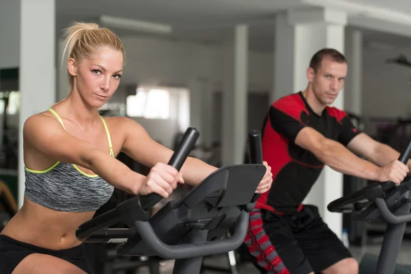 Des gens en bonne santé à vélo dans le gymnase de fitness — Photo