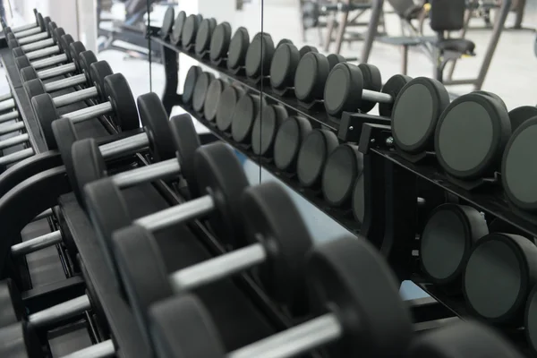 Rangées d'haltères dans la salle de gym — Photo