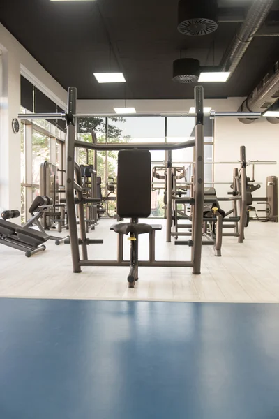 Intérieur de la nouvelle salle de gym moderne avec équipement — Photo