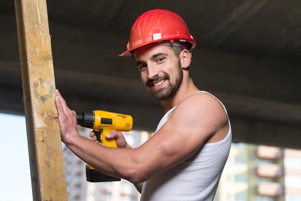 Perforación del trabajador un gran tablón de madera — Foto de Stock