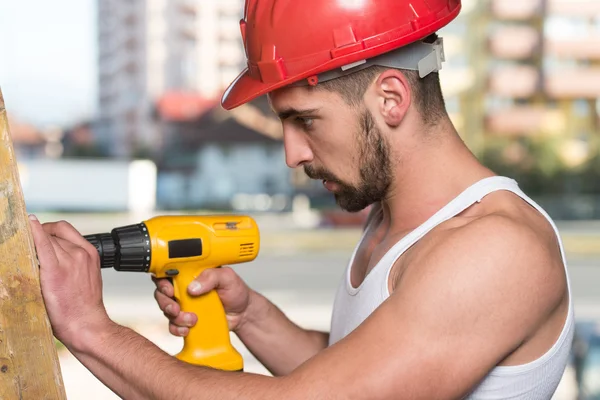 Perforación del trabajador un gran tablón de madera — Foto de Stock