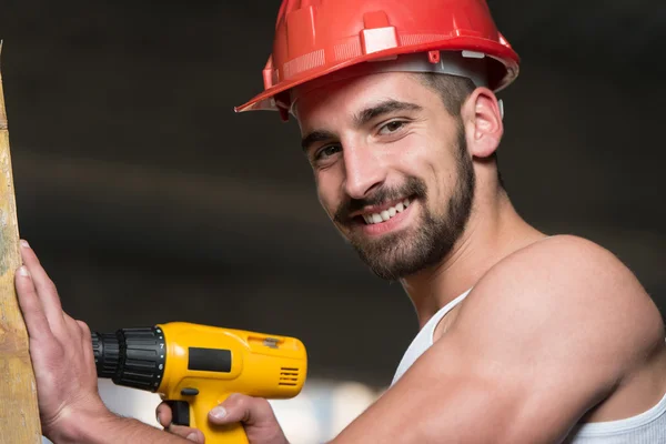 Perforación del trabajador un gran tablón de madera — Foto de Stock