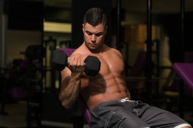 Pazı egzersiz Dumbbells ile genç adam