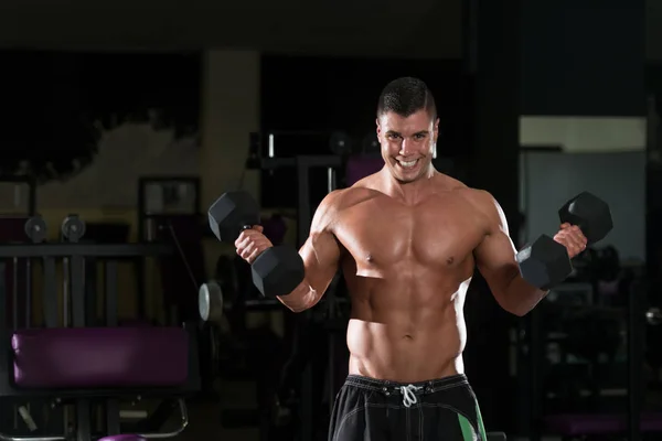 Jeune homme avec haltères exercice Biceps — Photo