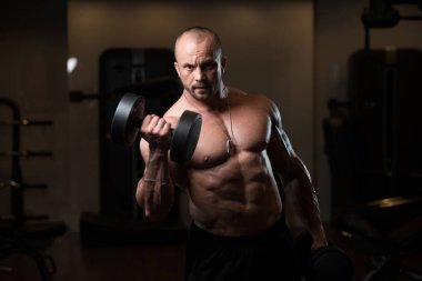 Pazı egzersiz bir spor salonunda Dumbbells ile