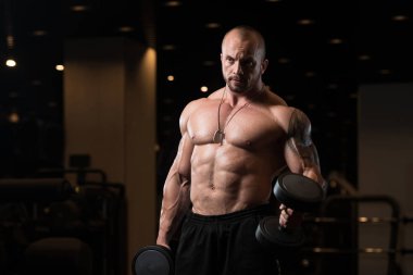 Pazı spor salonunda egzersiz Dumbbells ile adam