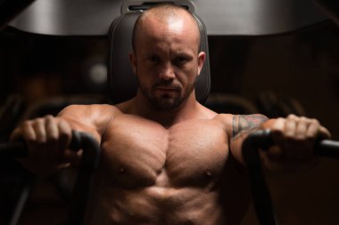 Adam makine ile göğsüne üzerinde çalışıyor