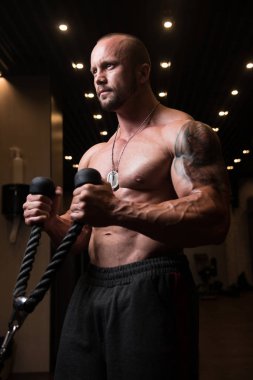 Kaslı adam pazı kablo makinede egzersiz