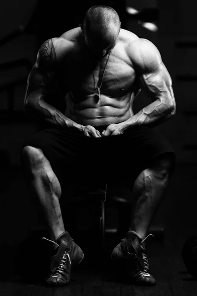 М'язистий чоловік згинає м'язи в тренажерному залі — стокове фото