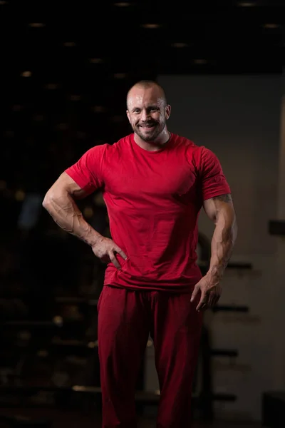 Fitness a forma di uomo muscolare in posa in palestra scura — Foto Stock
