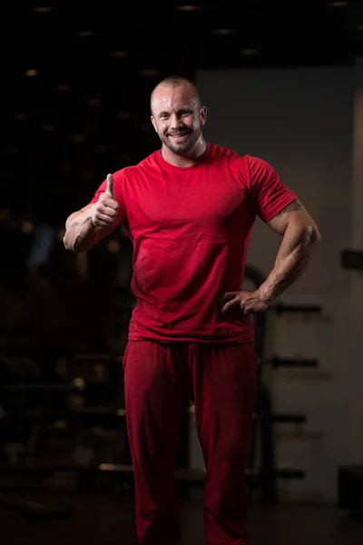 Uomo muscolare mostrando pollici in su — Foto Stock