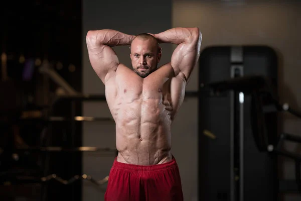 Muskulös man flexar muskler i gymmet — Stockfoto