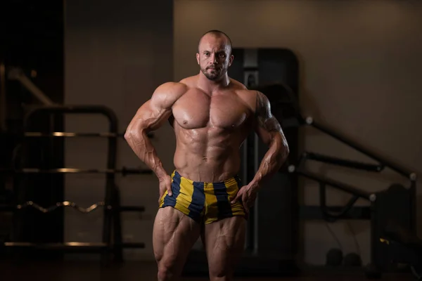 Atleta musculoso culturista posando en el gimnasio —  Fotos de Stock