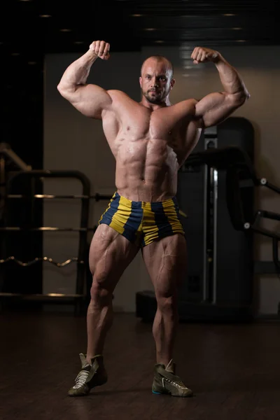 Bodybuilder posiert im Fitnessstudio — Stockfoto