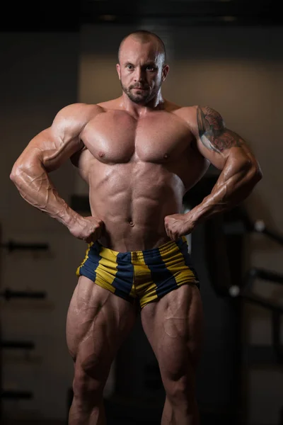 Bodybuilder homme posant dans la salle de gym — Photo