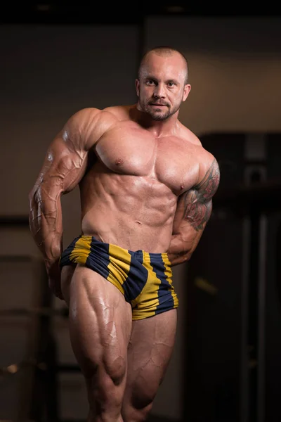 Idrottsman muskulös Bodybuilder poserar i gymmet — Stockfoto