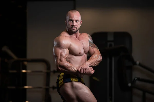 Bodybuilder posiert im Fitnessstudio — Stockfoto