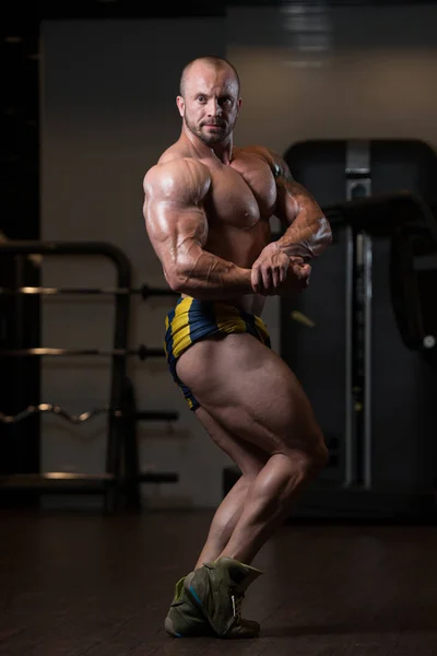 Bodybuilder man poserar i gymmet — Stockfoto