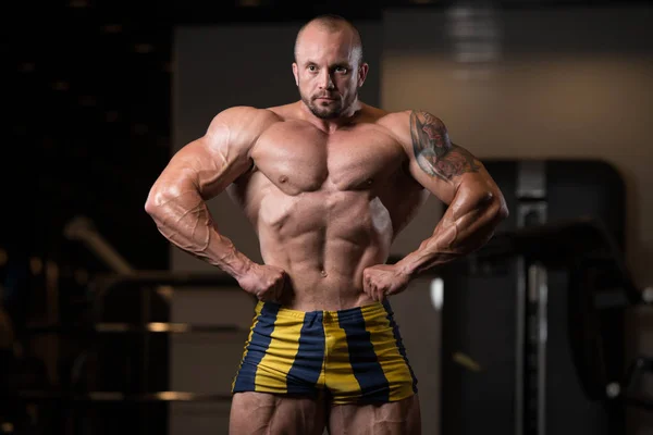 Sportler muskulöser Bodybuilder posiert in der Turnhalle — Stockfoto
