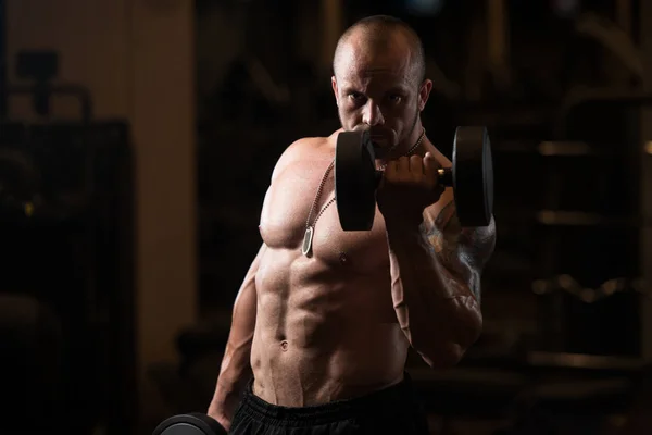 Hombre con sombrillas ejercitando bíceps en el gimnasio —  Fotos de Stock