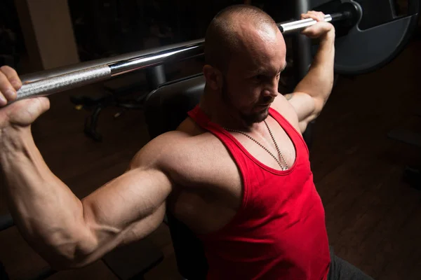 Muskulös Man gör tung vikt övning för axlarna — Stockfoto