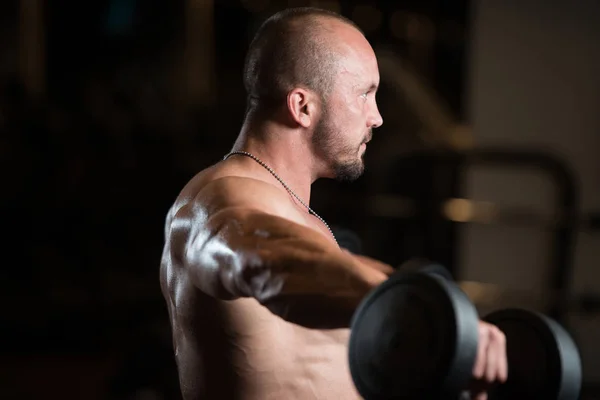 Musculado Masculino Modelo Exercício Ombro com halteres — Fotografia de Stock