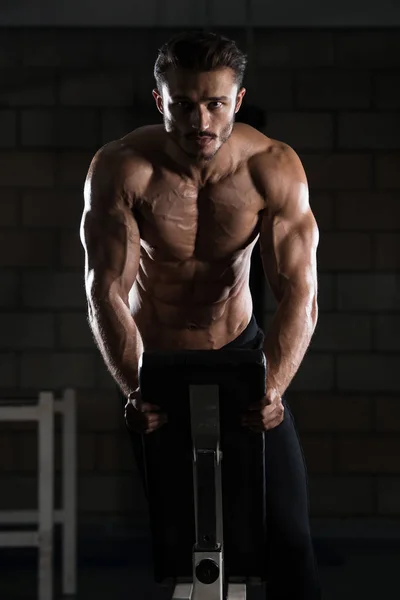 Bodybuilder utövar Push Ups på bänk — Stockfoto