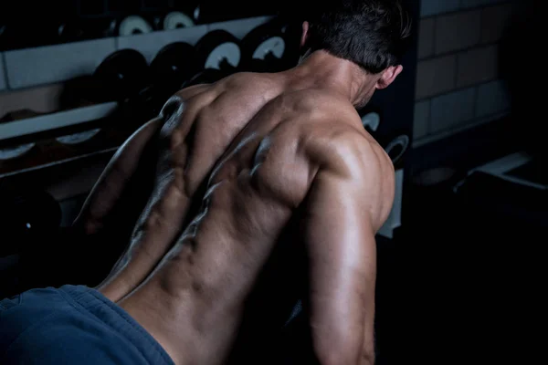 Jonge Man uitoefening terug In de sportschool — Stockfoto