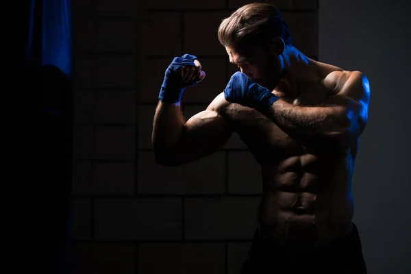 Hombre atractivo con bolsa de boxeo — Foto de Stock