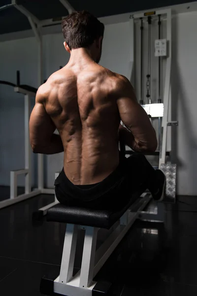 Мускулистый человек делает тяжелые упражнения веса для спины — стоковое фото