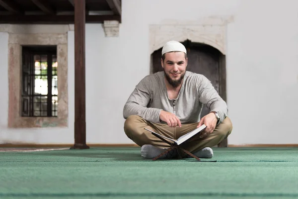 Junger muslimischer Kerl liest den Koran — Stockfoto