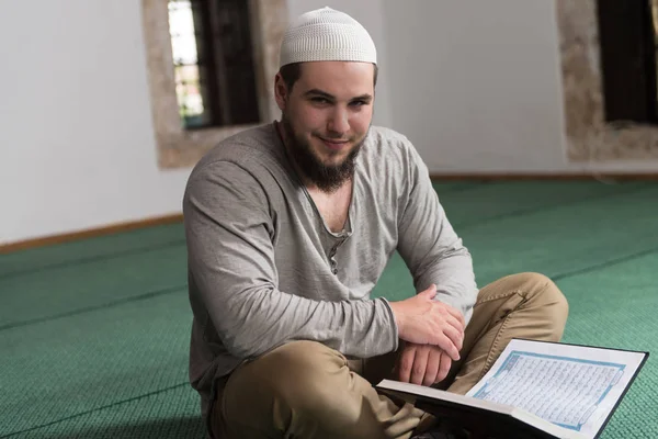 Arabischer muslimischer Mann liest heiliges islamisches Buch Koran — Stockfoto