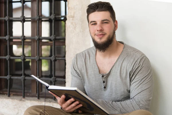 Νεαρός μουσουλμάνος άντρας ανάγνωση του Κορανίου — Φωτογραφία Αρχείου
