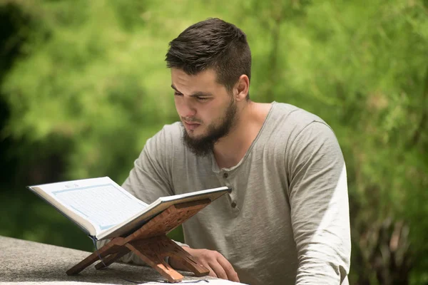 Muslimsk Man läser Koranen i Park — Stockfoto