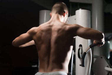 Kaslı adam arka için ağır egzersiz yaparak