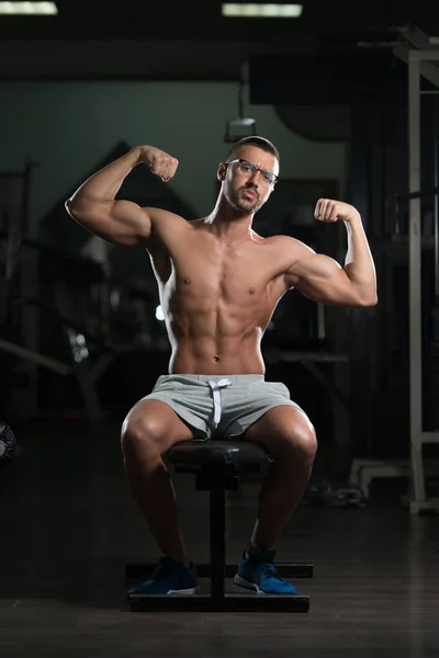 Muscular Geek Hombre Flexing Músculos En Gimnasio — Foto de Stock