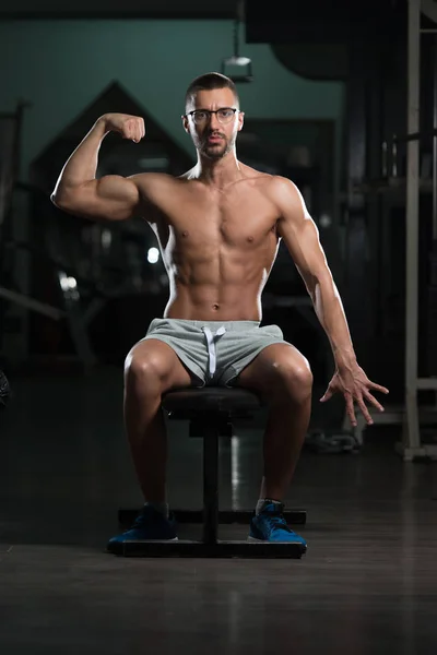 Muskulös Geek Man flexar muskler i gymmet — Stockfoto