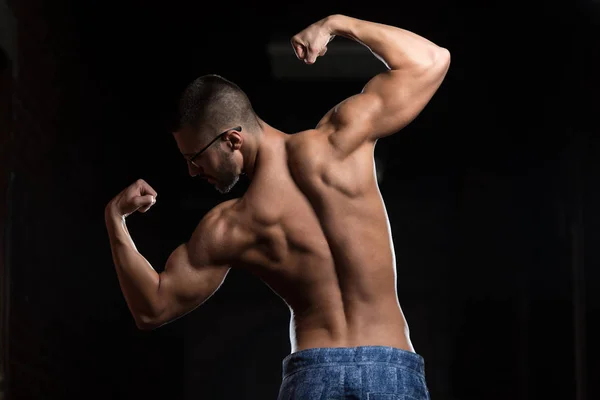 Nerd-Mann sitzt stark im Fitnessstudio — Stockfoto