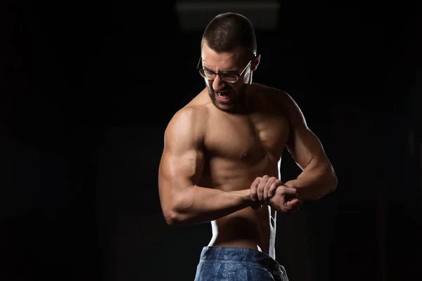 Jonge Bodybuilder dragen van bril buigen spieren — Stockfoto