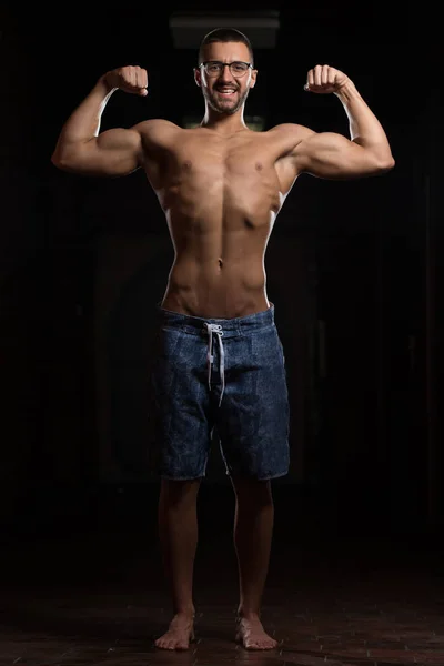 Young Bodybuilder Wearing Eyeglasses Flexing Muscles — Stock Photo, Image