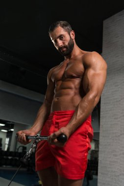 Kaslı adam pazı kablo makinede egzersiz