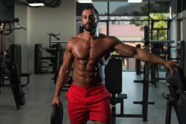 Ağırlıkları elinde tutan adam uygun