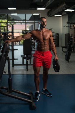 Ağırlıkları elinde tutan vücut geliştirmeci