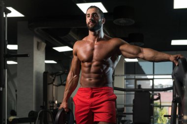 Ağırlıkları elinde tutan adam uygun