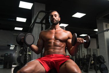 Pazı egzersiz Dumbbells ile genç adam